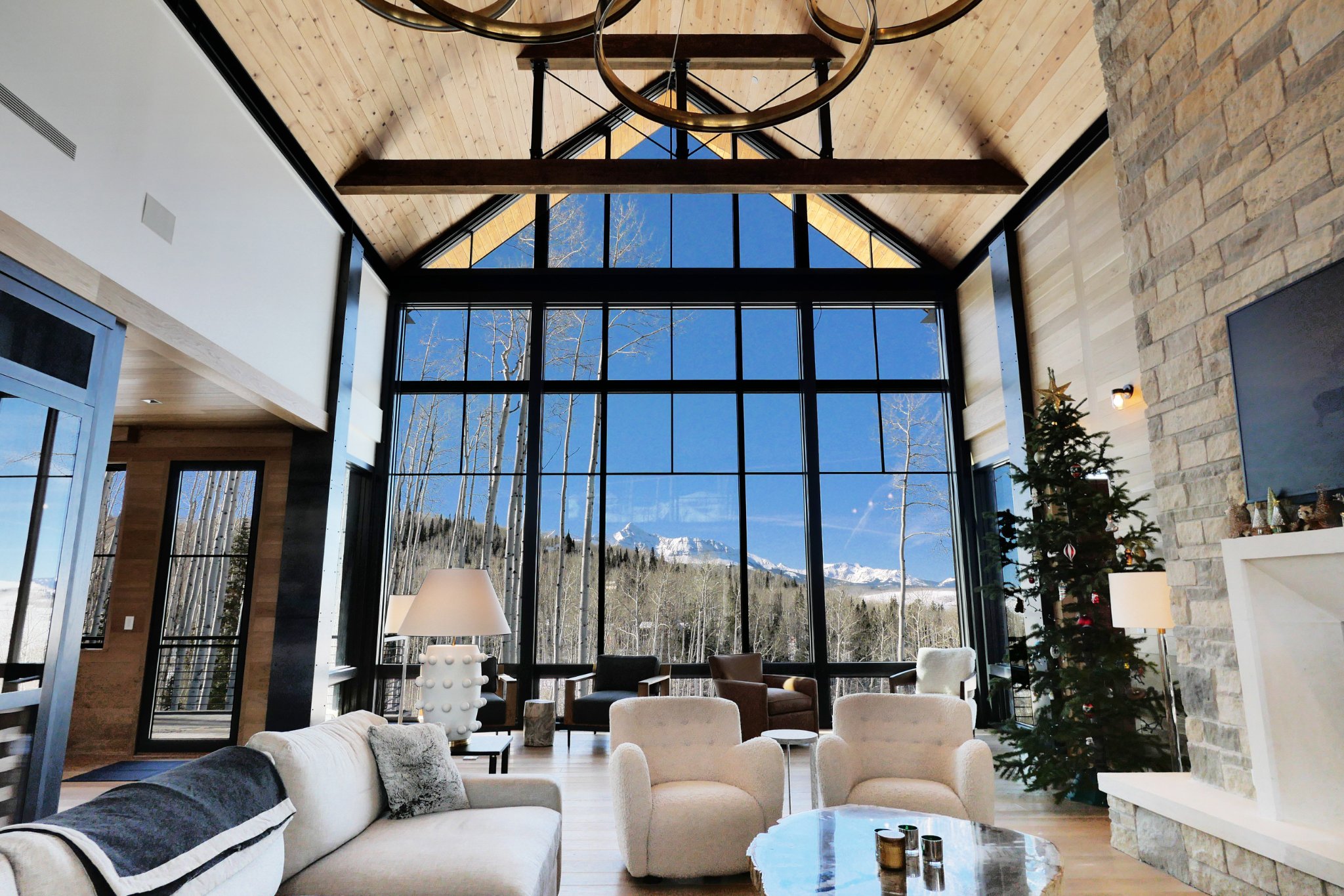 Great room — stone fireplace, vaulted ceilings, wall of glass